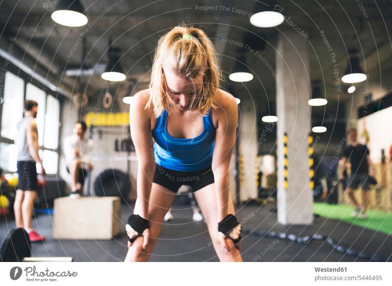 Erschöpfte junge Frau im Fitnessstudio macht eine Pause trainieren Erschöpfung erschöpft weiblich Frauen Erwachsener erwachsen Mensch Menschen Leute People