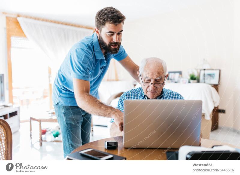 Erwachsener Enkel bringt seinem Großvater den Umgang mit dem Laptop bei Opa Großpapa Großpapas Opas Opi Großväter Opis Notebook Laptops Notebooks Senior