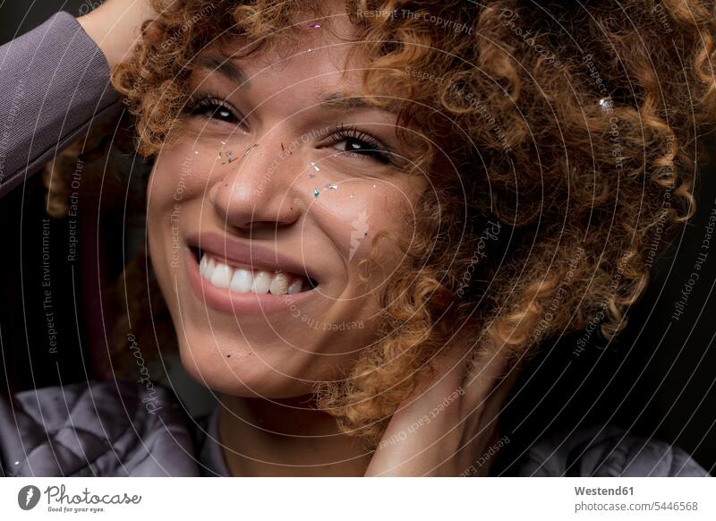 Porträt einer glücklichen Frau mit Konfetti im Gesicht Portrait Porträts Portraits Glück glücklich sein glücklichsein Gesichter Confetti weiblich Frauen Kopf