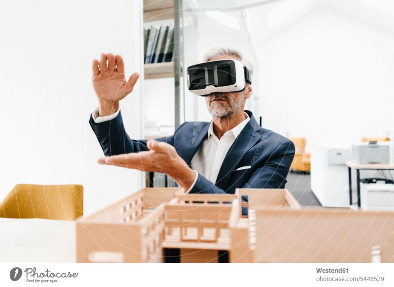 Reifer Geschäftsmann mit Architekturmodell im Büro mit VR-Brille Businessmann Businessmänner Geschäftsmänner Office Büros Architekten 3D Brille 3D-Brille Modell