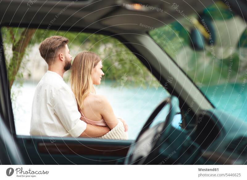 Junges Paar vor dem Auto mit Blick auf Aussicht Pärchen Paare Partnerschaft Liebe lieben glücklich Glück glücklich sein glücklichsein entspannt entspanntheit