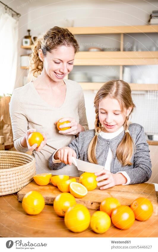Mutter und Tochter schneiden Orangen in der Küche Mami Mutti Mütter Mama Töchter Küchen Apfelsinen Eltern Familie Familien Mensch Menschen Leute People Personen