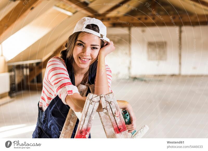 Junge Frau, die ihr neues Haus renoviert, hält Farbroller Heimwerken Do-it-Yourself DIY junge Frau junge Frauen Eigenheim Eigenheime wohnen renovieren