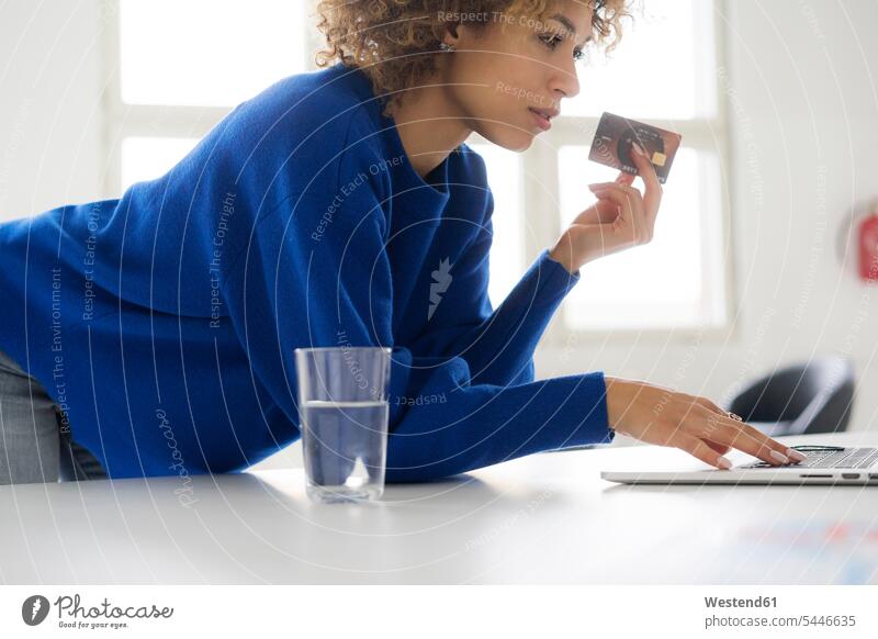 Frau bezahlt ihre Online-Bestellung mit Kreditkarte weiblich Frauen benutzen benützen bestellen bezahlen Laptop Notebook Laptops Notebooks Tisch Tische EC-Karte