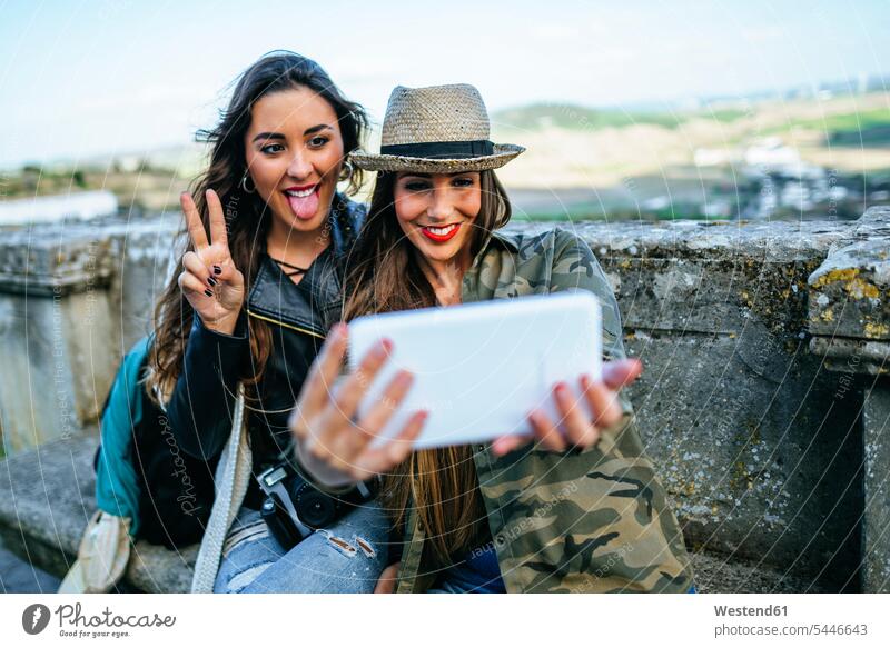 Zwei glückliche junge Frauen auf einer Reise machen ein Selfie mit einem Tablet Selfies Freundinnen lächeln fotografieren Tablet Computer Tablet-PC Tablet PC