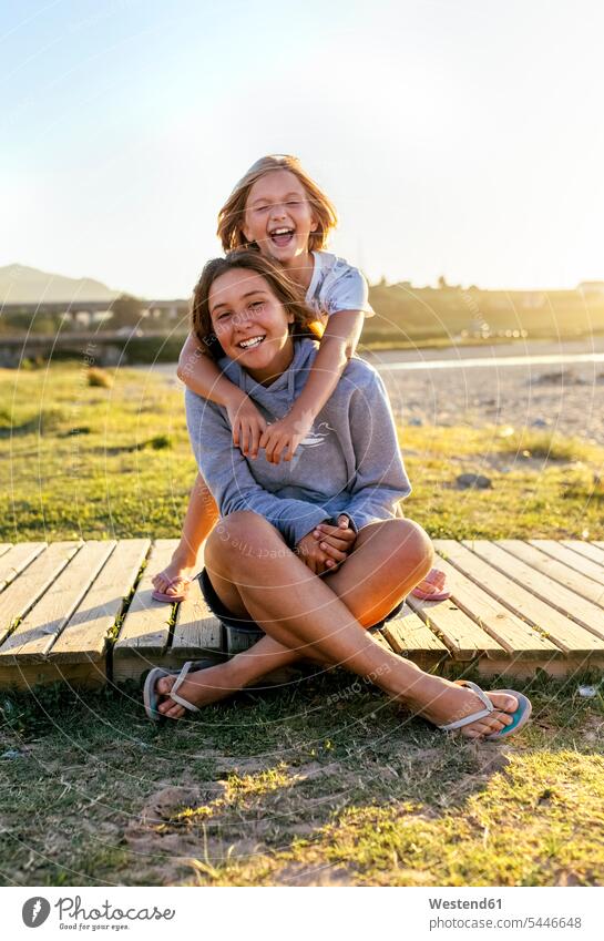 Porträt von zwei lachenden Mädchen auf der Strandpromenade Freundinnen Portrait Porträts Portraits weiblich Freunde Freundschaft Kameradschaft Kind Kinder Kids
