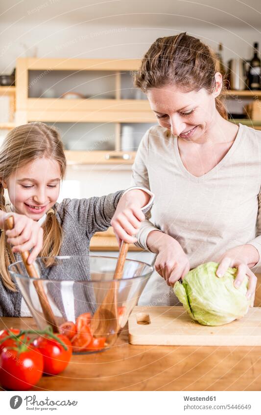 Mutter und Tochter bereiten in der Küche Salat zu Mami Mutti Mütter Mama Töchter Küchen schneiden Tomate Speisetomaten Tomaten Eltern Familie Familien Mensch