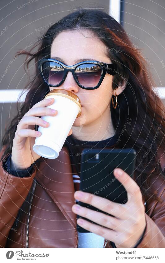 Porträt einer jungen Frau mit Kaffee zum Mitnehmen, die ein Selfie mit ihrem Smartphone macht weiblich Frauen Selfies Erwachsener erwachsen Mensch Menschen