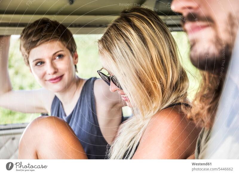Lächelnde Freunde in einem Lieferwagen ansehen Kleinbus Kleinbusse Spaß Spass Späße spassig Spässe spaßig lächeln Freundschaft Kameradschaft schauen sehend