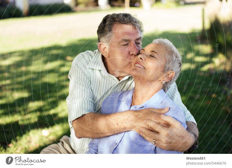 Älterer Mann küsst seine Frau im Garten küssen Küsse Kuss glücklich Glück glücklich sein glücklichsein Gärten Gaerten Paar Pärchen Paare Partnerschaft
