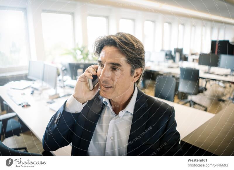 Geschäftsmann im Büro am Handy telefonieren anrufen Anruf telephonieren Businessmann Businessmänner Geschäftsmänner Mobiltelefon Handies Handys Mobiltelefone