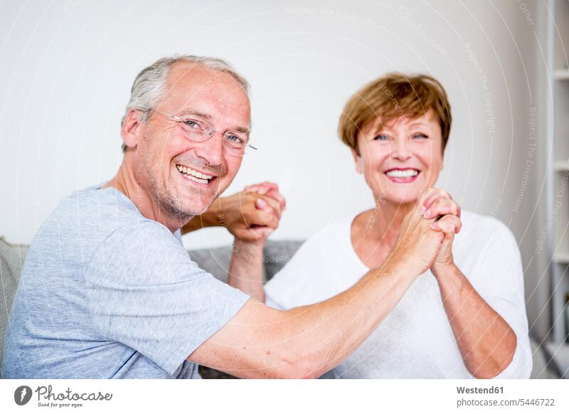 Porträt eines glücklichen älteren Ehepaares zu Hause Sofa Couches Liege Sofas Paar Pärchen Paare Partnerschaft entspannt entspanntheit relaxt Mensch Menschen