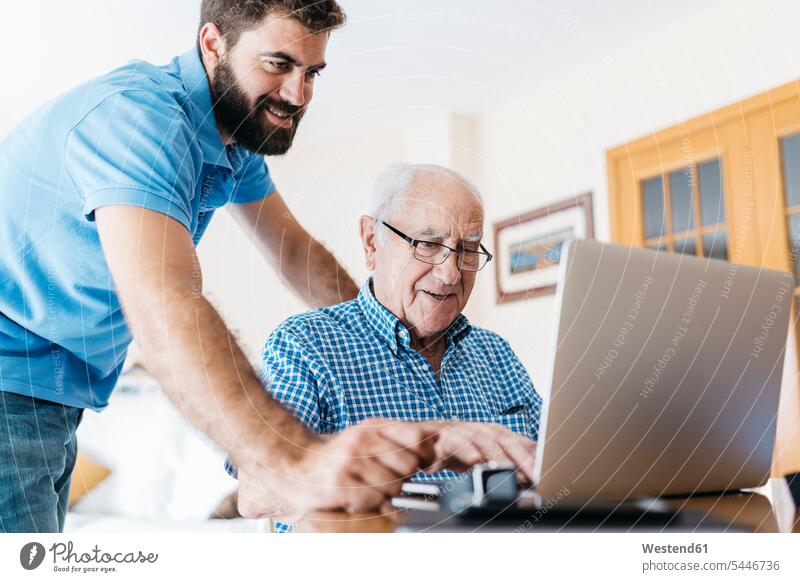 Erwachsener Enkel bringt seinem Großvater den Umgang mit dem Laptop bei Opa Großpapa Großpapas Opas Opi Großväter Opis Enkelsöhne Enkelsohn Senior ältere Männer