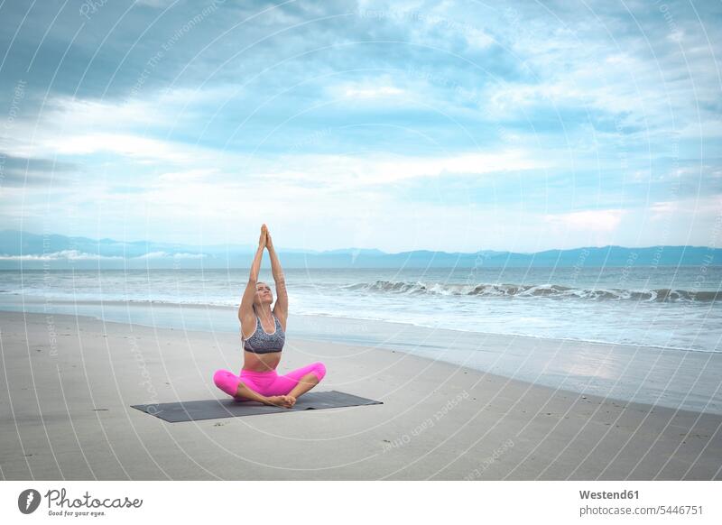 Frau praktiziert Yoga am Strand Beach Straende Strände Beaches weiblich Frauen sportlich fit üben ausüben Übung trainieren Yoga-Übungen Yogauebungen Yogaübungen