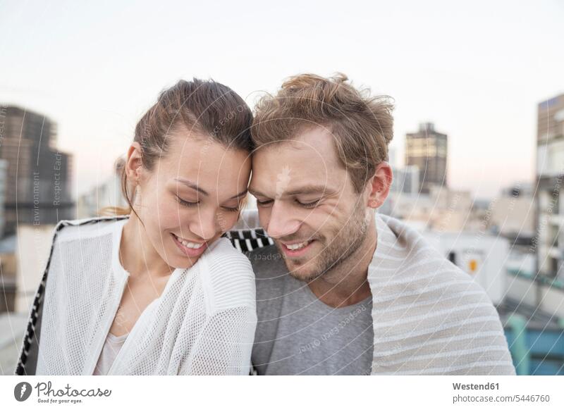 Romantisches Paar sitzt auf der Dachterrasse und genießt die Aussicht Pärchen Paare Partnerschaft Brüstung Balustrade frisch verliebt sich verlieben glücklich
