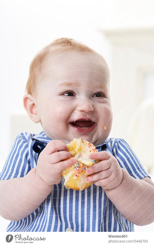 Porträt eines glücklichen kleinen Jungen mit Muffin lachen essen essend Baby Babies Babys Säuglinge Kind Kinder Portrait Porträts Portraits positiv Emotion