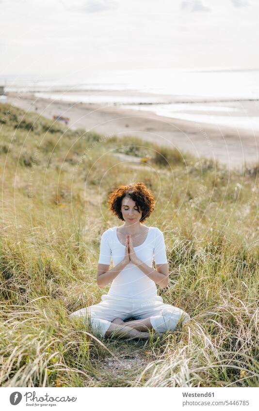 Frau praktiziert Yoga in Stranddüne Yoga-Übungen Yogauebungen Yogaübungen Jogauebung Jogauebungen Sanddüne Sanddünen Beach Straende Strände Beaches weiblich