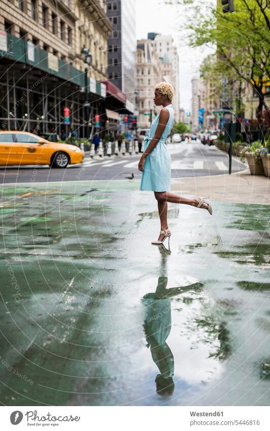 USA, New York, junge blonde afro-amerikanische Frau auf einem Bein stehend Straße Strassen Straßen steht Mode modisch Fashion Afroamerikanisch Afro-Amerikanisch