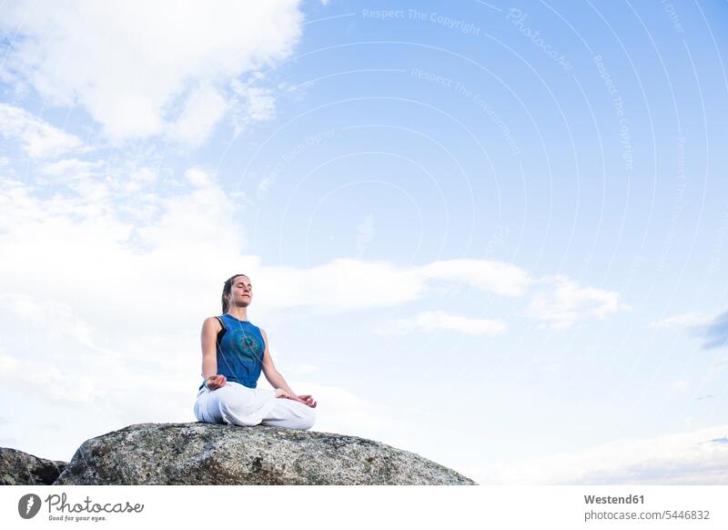 Frau beim Yoga auf einem Felsen sitzend sitzt weiblich Frauen Übung Uebung Übungen Uebungen Erwachsener erwachsen Mensch Menschen Leute People Personen Natur