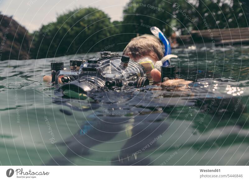 Mann mit Unterwasser-DSLR-Kamerakoffer in einem See Taucher Kameras tauchen Männer männlich Fotoapparat Fotokamera Wassersport Sport Erwachsener erwachsen