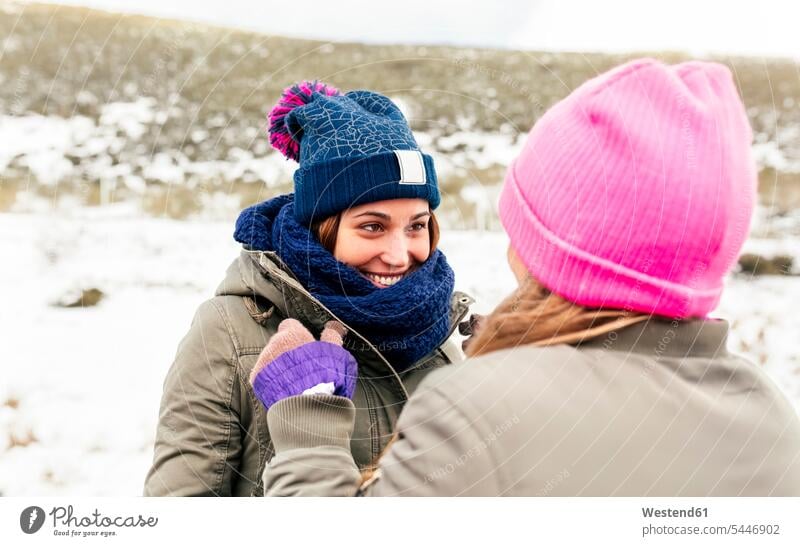Zwei Freunde amüsieren sich im Schnee Freundinnen lachen Winter winterlich Winterzeit Freundschaft Kameradschaft Wetter positiv Emotion Gefühl Empfindung