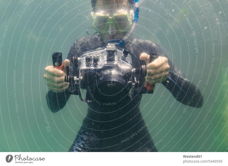 Mann taucht mit Unterwasser-DSLR-Kameratasche tauchen Kameras Männer männlich Taucher Fotoapparat Fotokamera Erwachsener erwachsen Mensch Menschen Leute People