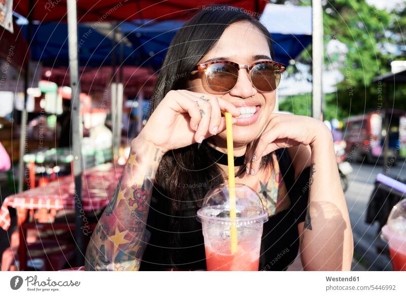Porträt einer glücklichen Frau, die im Freien einen Smoothie trinkt trinken Smoothies Glück glücklich sein glücklichsein weiblich Frauen Getränk Getraenk