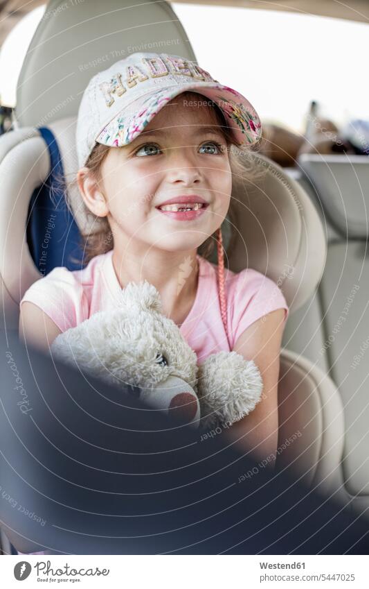 Mädchen sitzt im Auto und hält Teddybär Wagen PKWs Automobil Autos weiblich Teddybaer Teddybaeren Teddybären halten sitzen sitzend Autoreise lächeln Urlaub