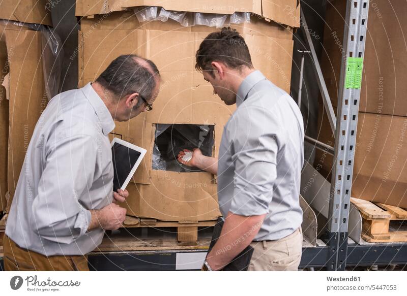 Zwei Männer untersuchen Produkt im Fabriklager sprechen reden Kollegen Arbeitskollegen Fabriken Mann männlich Erwachsener erwachsen Mensch Menschen Leute People