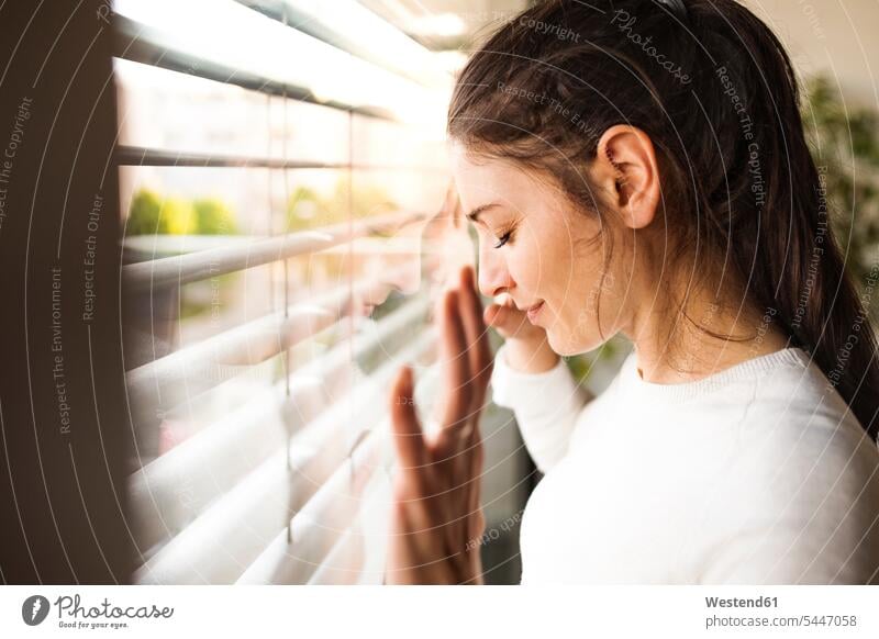 Frau zu Hause, die aus dem Fenster schaut weiblich Frauen Erwachsener erwachsen Mensch Menschen Leute People Personen lächeln Ruhe Beschaulichkeit ruhig