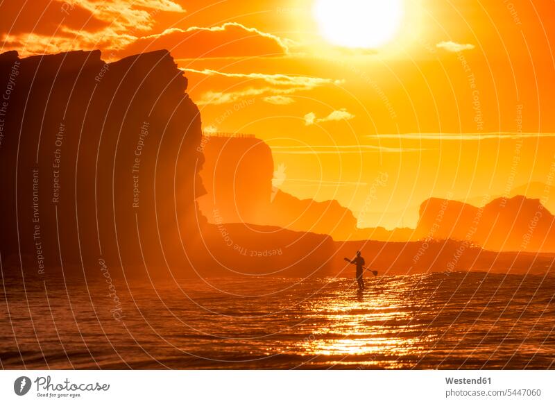 Großbritannien, Schottland, East Lothian, Paddle-Board-Surfen bei Sonnenuntergang paddeln paddelnd paddelt Stehpaddeln Stand Up Paddling Paddelsurfen