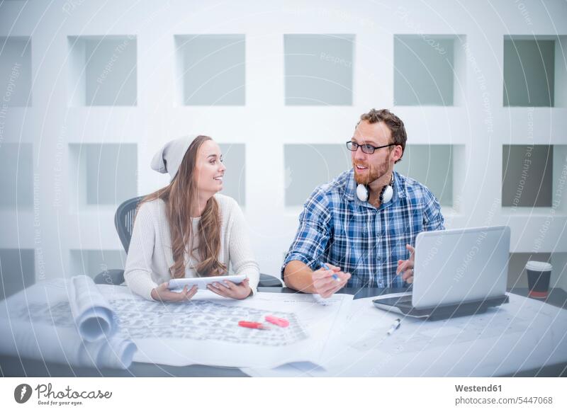 Junger Mann und Frau diskutieren Projekt im Designbüro besprechen Besprechung Designer Gemeinsam Zusammen Miteinander Büro Office Büros arbeiten Arbeit Laptop