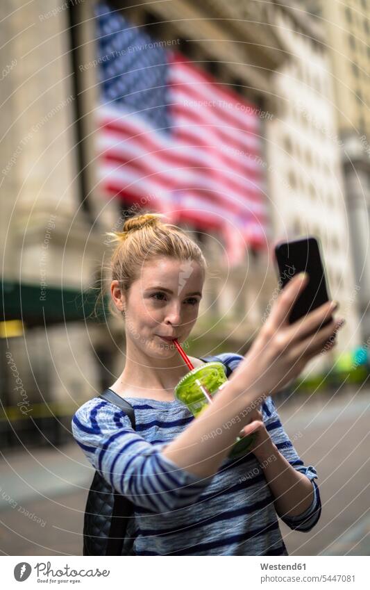 USA, New York City, Frau macht Selfie vor der New York Stock Exchange Selfies weiblich Frauen Handy Mobiltelefon Handies Handys Mobiltelefone Erwachsener
