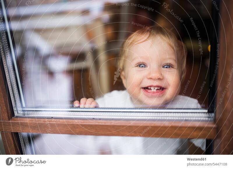 Lachender kleiner Junge schaut aus dem Fenster lachen männliche Babys männliches Baby männliche Babies Kind Kinder positiv Emotion Gefühl Empfindung Emotionen