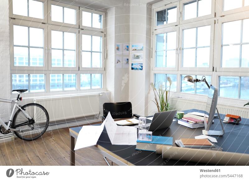 Interieur eines modernen informellen Büros Schreibtisch Arbeitstisch Schreibtische leer leere Laptop Notebook Laptops Notebooks Office Fahrrad Bikes Fahrräder