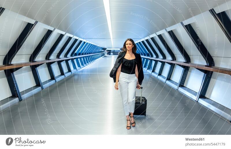 Geschäftsfrau mit Koffer beim Gang durch einen Tunnel gehen gehend geht Geschäftsfrauen Businesswomen Businessfrauen Businesswoman Geschäftsleute