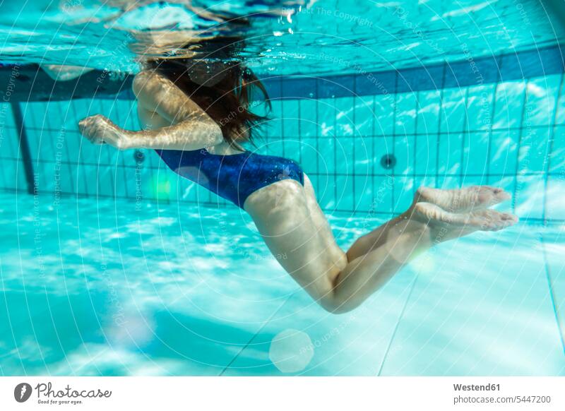 Mädchen schwimmt unter Wasser im Schwimmbad weiblich schwimmen Unterwasser Unterwasseraufnahme Unterwasserfoto Schwimmbaeder Schwimmbäder Kind Kinder Kids