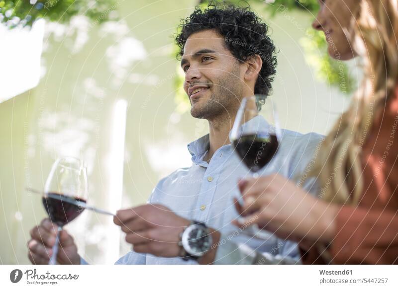 Junger Mann mit Weinglas macht eine Ankündigung feiern Paar Pärchen Paare Partnerschaft Weine Rotwein Rotweine Mensch Menschen Leute People Personen Alkohol