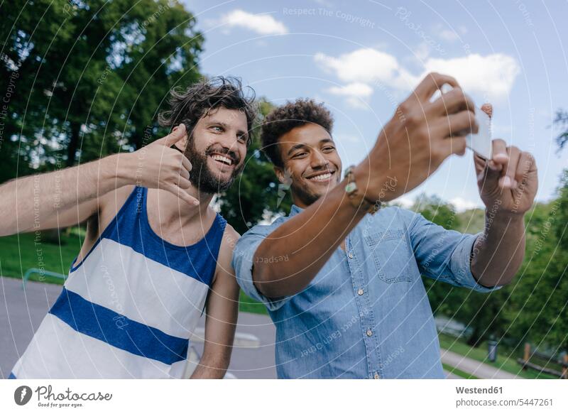 Zwei glückliche Freunde machen ein Selfie in einem Skatepark Selfies Mann Männer männlich Skateboardpark Skateboard-Park Skateboard Park Skaterplatz Glück