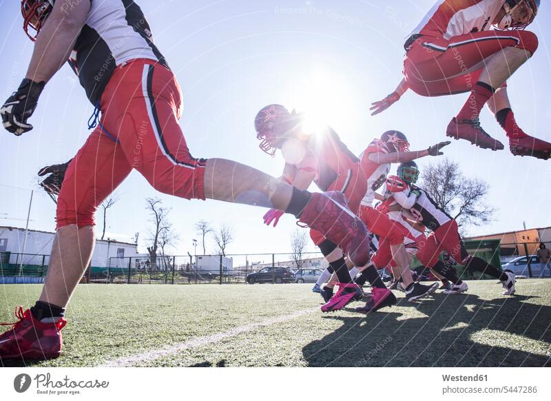 American-Football-Spieler, der während eines Spiels mit dem Ball springt Match Helm Helme springen hüpfen American Football Sprung Spruenge Sprünge Sport