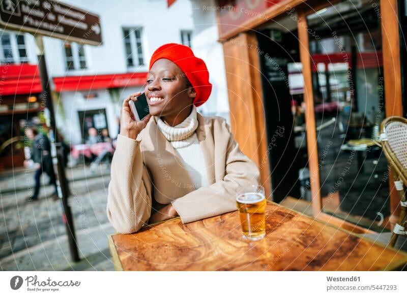Junge Frau in Paris sitzt in einem Café und telefoniert telefonieren anrufen Anruf telephonieren lächeln Cafe Kaffeehaus Bistro Cafes Cafés Kaffeehäuser