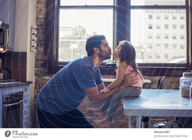 Vater und Tochter küssen sich in der Küche Papas Väter Vati Vatis Papis Töchter Küsse Kuss Zuhause zu Hause daheim Eltern Familie Familien Mensch Menschen Leute