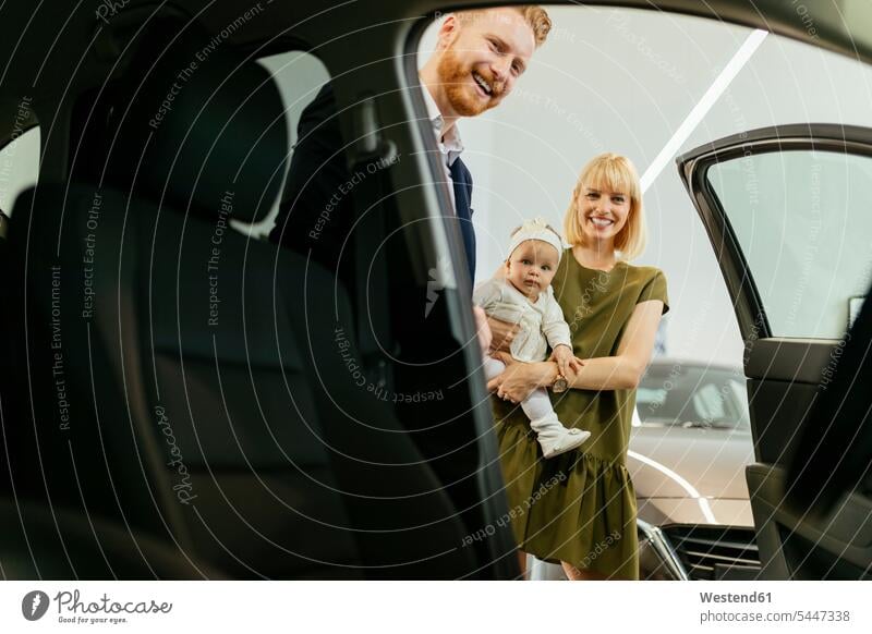 Familie im Autohaus entscheidet sich für Familienfahrzeug Familienauto Autohäuser Autohaeuser Autohandlung Autohandlungen Ausstellungsraum aussuchen auswählen