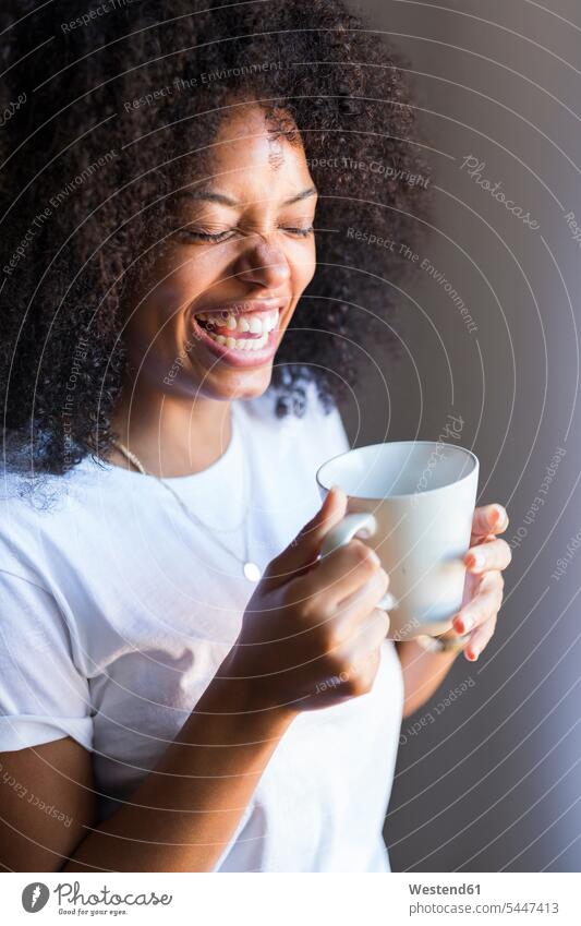 Lachende Frau hält Tasse Kaffee in der Hand lachen weiblich Frauen Getränk Getraenk Getränke Getraenke Food and Drink Lebensmittel Essen und Trinken