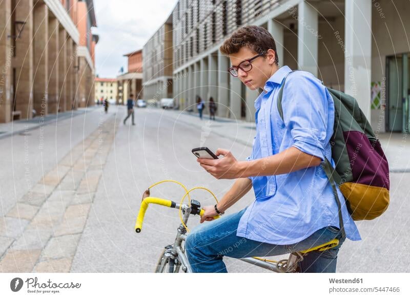 Junger Mann auf Rennrad schaut auf Handy Männer männlich Erwachsener erwachsen Mensch Menschen Leute People Personen ernst Ernst Ernsthaftigkeit ernsthaft