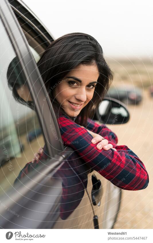 Junge Frau lehnt sich aus dem Autofenster Portrait Porträts Portraits weiblich Frauen Wagen PKWs Automobil Autos Erwachsener erwachsen Mensch Menschen Leute