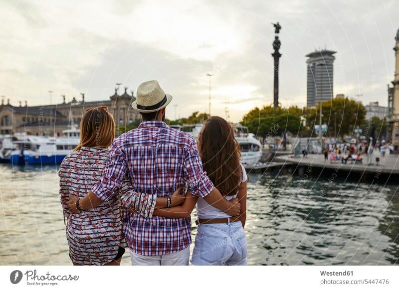 Spanien, Barcelona, drei Touristen, die sich am Wasser in der Stadt umarmen Freunde Pier Landungssteg Piers stehen stehend steht Umarmung Umarmungen Arm umlegen