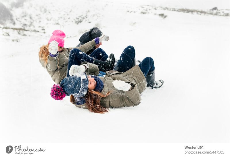 Drei Freunde gleiten auf dem Schnee Freundschaft Kameradschaft spielen lachen Winter winterlich Winterzeit positiv Emotion Gefühl Empfindung Emotionen Gefühle