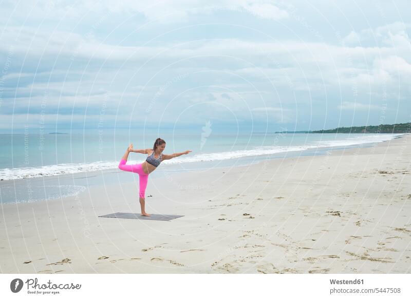 Frau praktiziert Yoga am Strand fit Yoga-Übungen Yogauebungen Yogaübungen Jogauebung Jogauebungen weiblich Frauen sportlich Beach Straende Strände Beaches üben