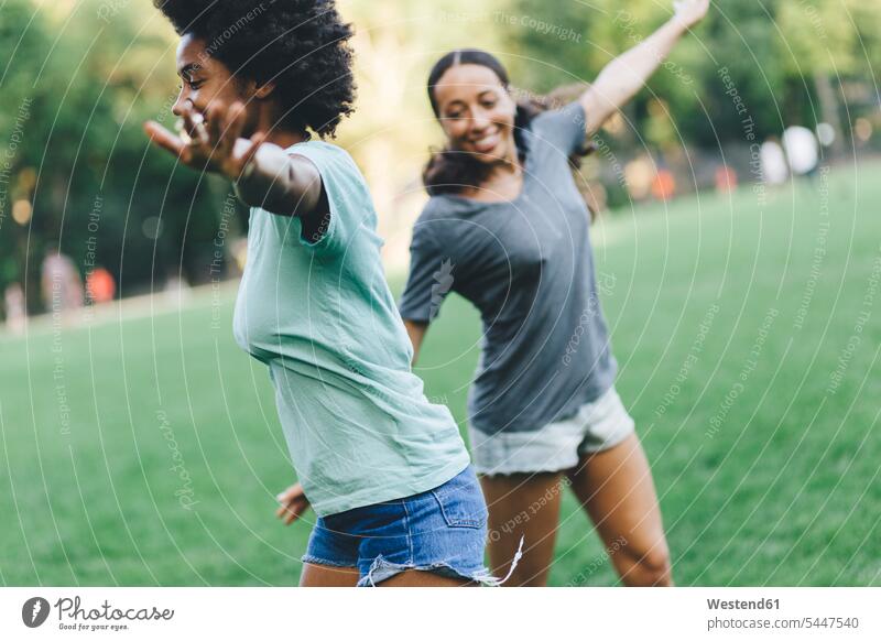 Zwei beste Freunde amüsieren sich abends gemeinsam im Park Parkanlagen Parks Freundinnen spielen Freundschaft Kameradschaft gehen gehend geht Afroamerikanisch